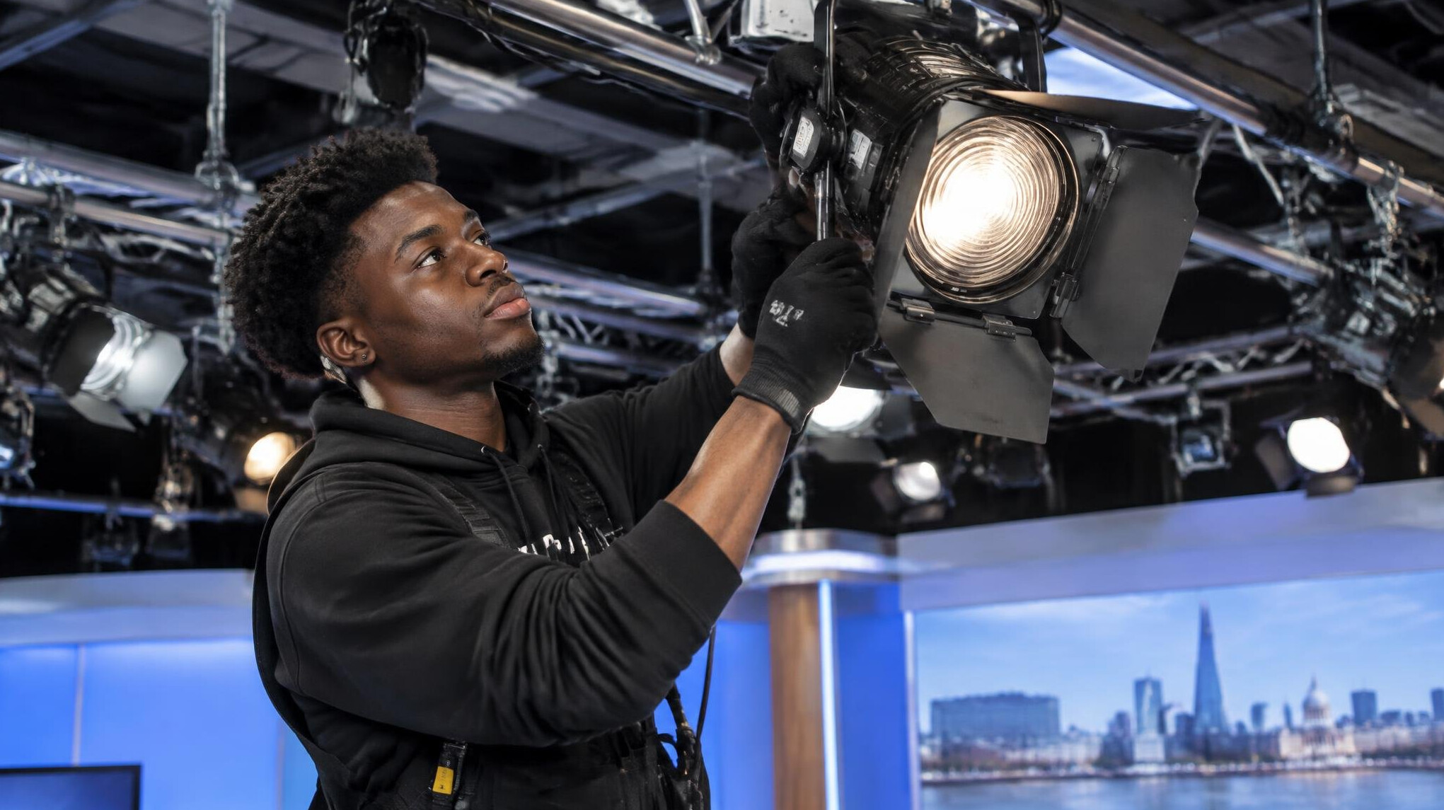 Technician adjusting studio lighting equipment